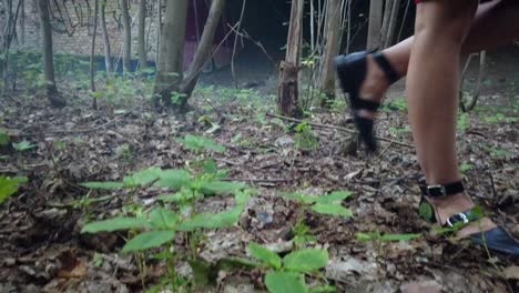 amazing slow motion cinematic shot of a young blond ukraine girl in red dress with black shoes standing and walk in a forrest. foto video shoot on lost places in nature 1080, 24p by philipp marnitz