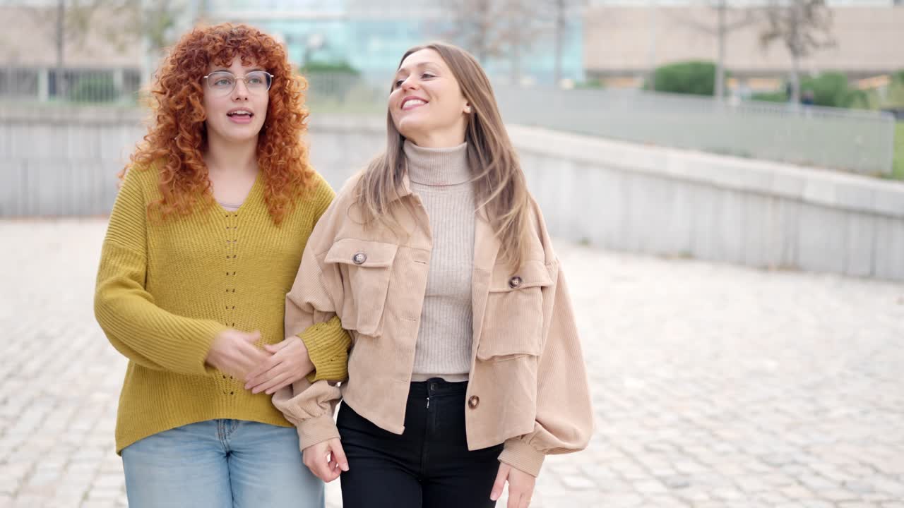 Friends walking relaxed together and talking along the street