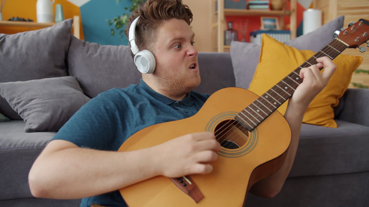 Man Singing and Playing Acoustic Guitar at Home