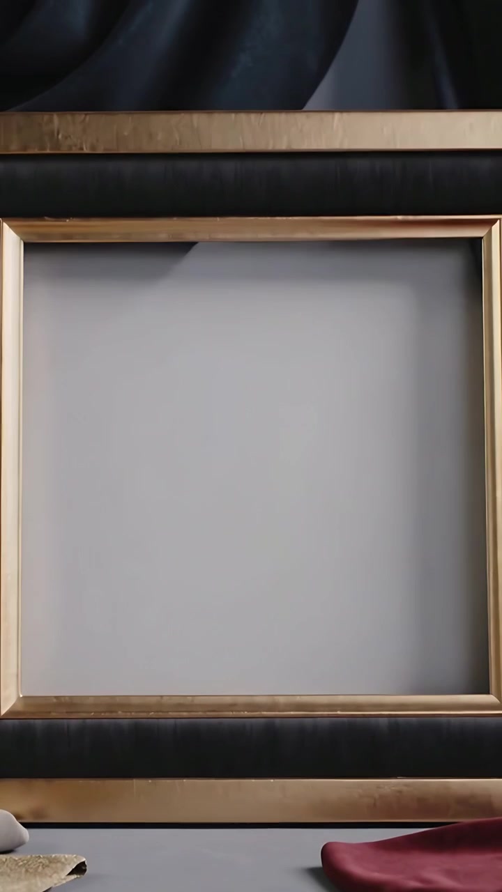 Vertikální video: Ruka v rukavici otáčí zlatý rám a vkládá šedou podložku na studiový stůl pro vystavení.