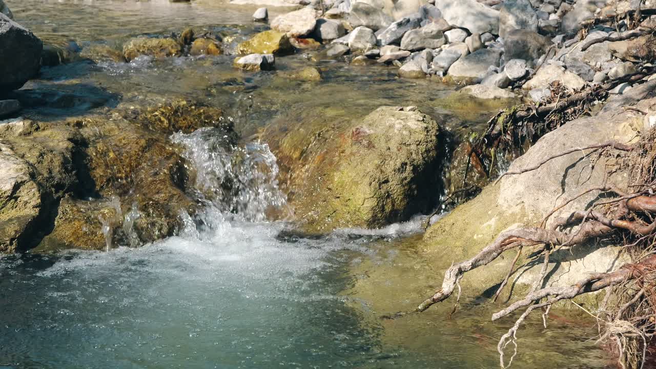 Static image of a clear, crystal stream in the Swiss Alps.