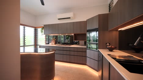 modern interior of home house luxury dark wood kitchen with gas stove under bench trip lighting and ample natural light