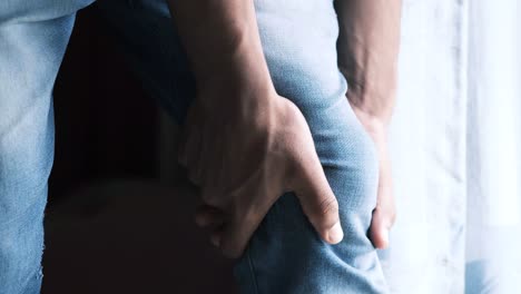 persona que sostiene su rodilla con dolor