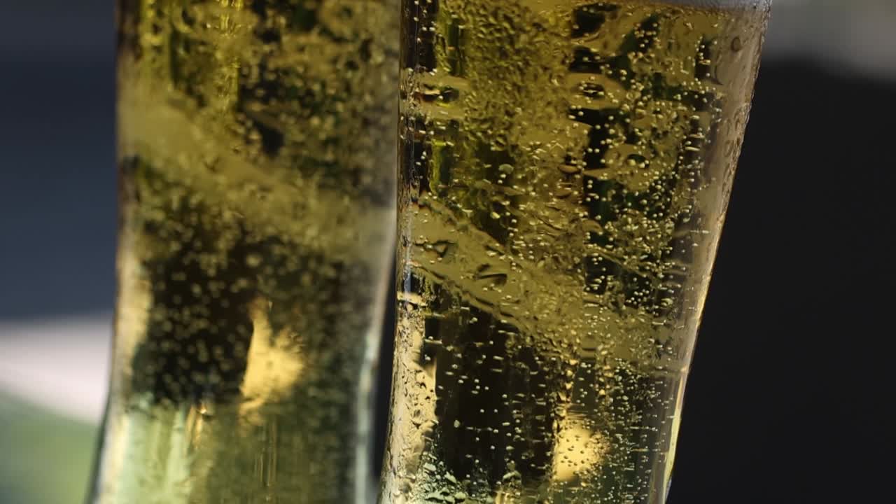 Primo piano di un bicchiere di birra con schiuma frizzante.