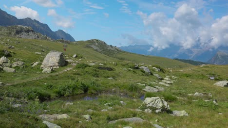 grassy mountainside field with rocks in valmalenco, sondrio, italy