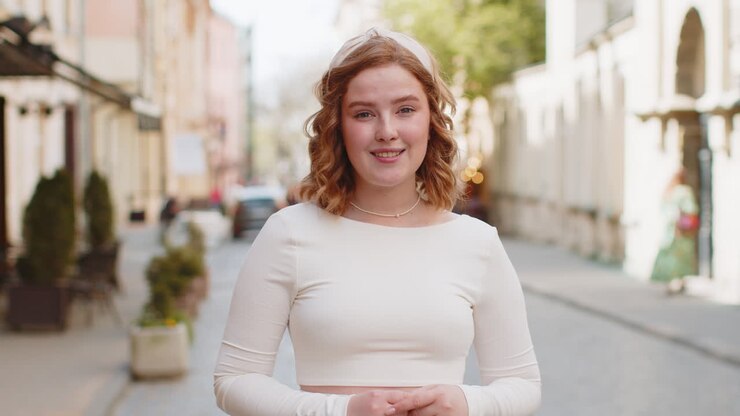 Happy redhead woman smiling looking away dreaming resting good news feel satisfied in city street