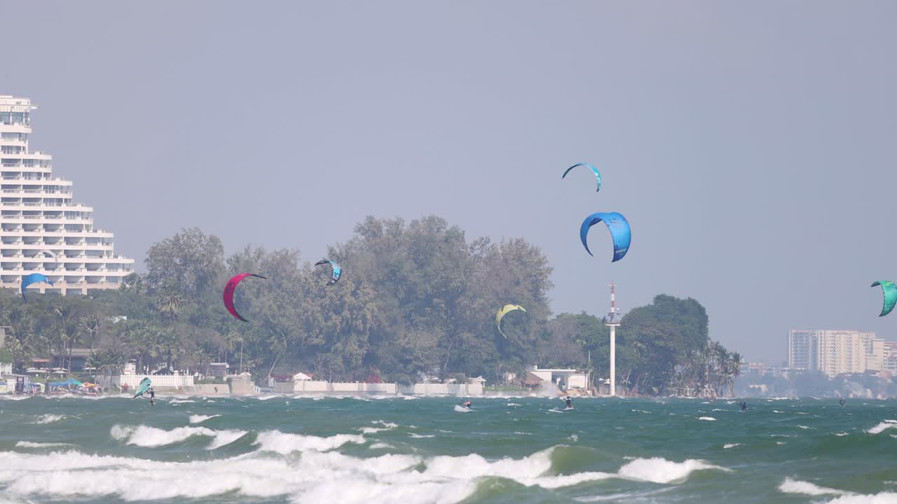카이트 서퍼 들 은 흔들리는 바다 파도 를 가로질러 미끄러진다