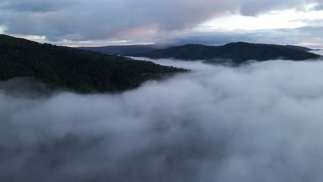 Vista-Aérea-Del-Paisaje-Sobre-Las-Nubes-Del-Bosque-En-Las-Montañas-Y-El-Horizonte-En-Chile