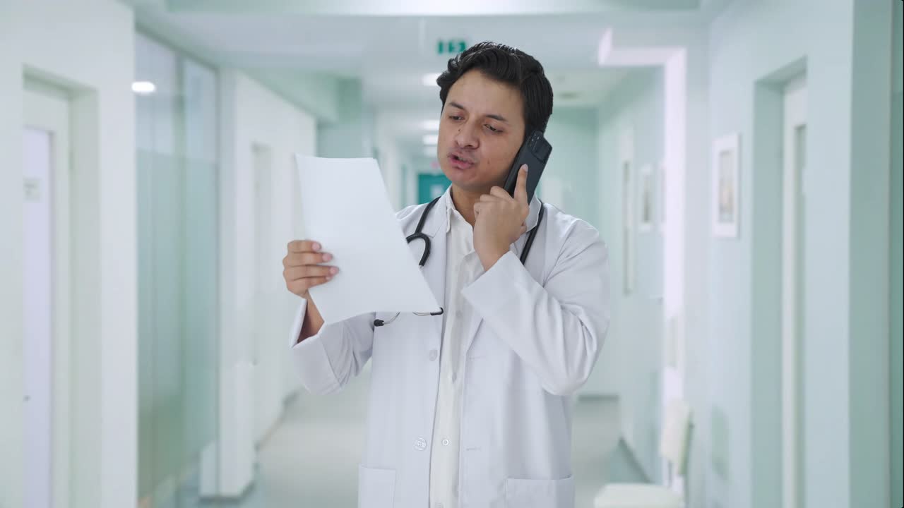 médico indio enojado explicando el informe médico en la llamada
