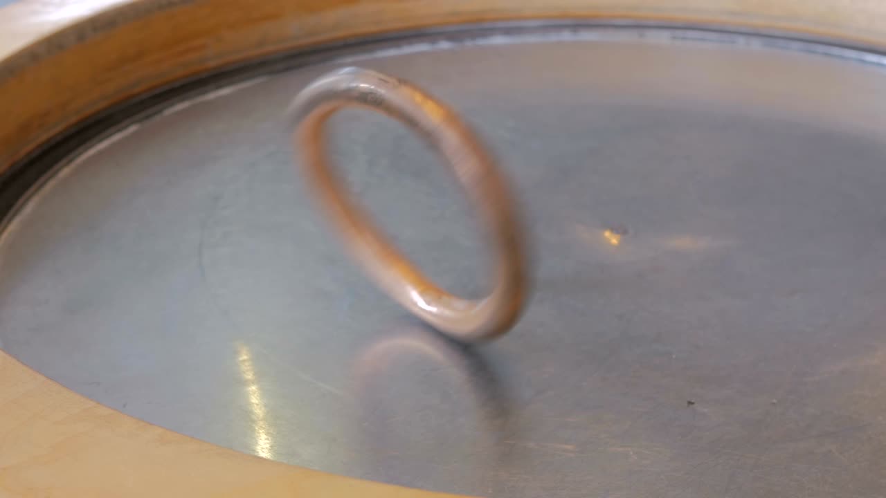 Woman hand play with ring on metal turning surface