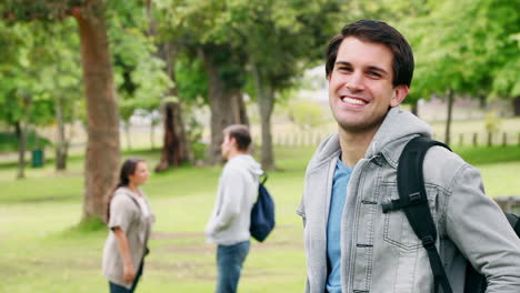 Man-laughing-as-he-reads-a-text-message-before-looking-at-the-camera-while-smiling