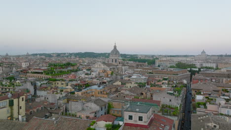 Volar-Por-Encima-De-Los-Edificios-En-El-Centro-De-La-Ciudad-Al-Atardecer.-Varias-Casas-Antiguas-Residenciales-En-Pleno-Urbano.-Torres-De-Iglesias-Que-Sobresalen-Por-Encima-De-Otros-Tejados.-Roma,-Italia