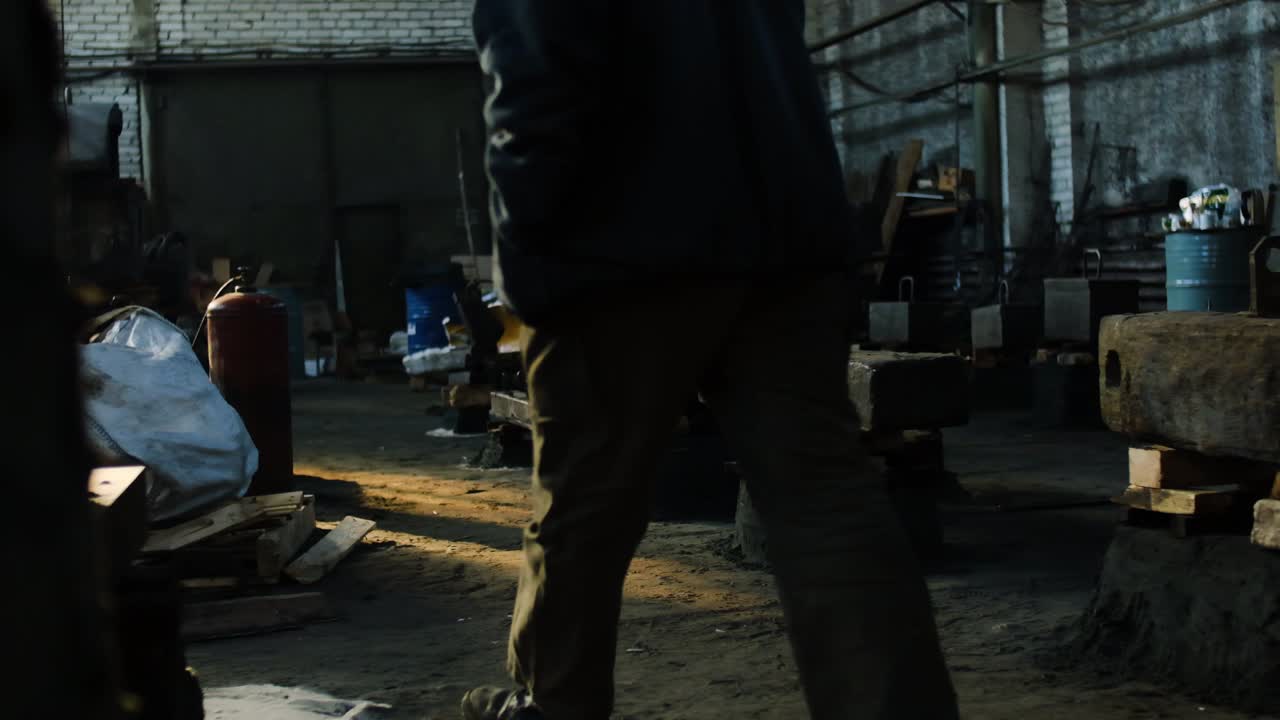 어두운 산업 작업실에서 일하는 노동자