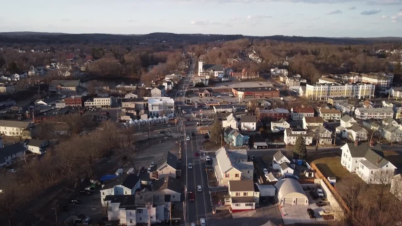 drone descendiendo sobre el tráfico de cercanías en la calle central de la ciudad de hudson, massachusetts durante el invierno