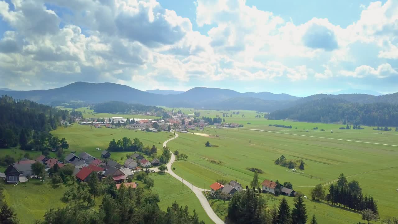 vista aérea al pequeño pueblo de eslovenia en las montañas con un hermoso campo