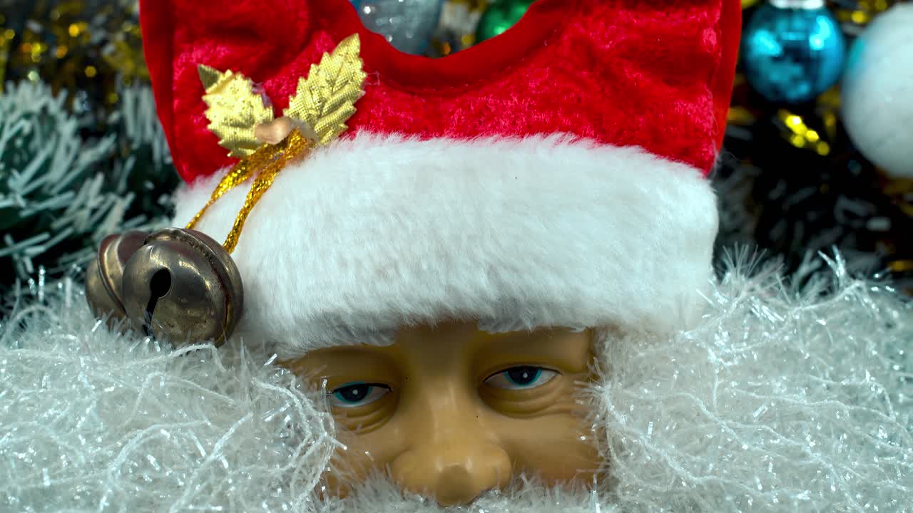 Santa Claus toy in a red hat with bells, Christmas decoration, traditional holiday presents, new year decor, shiny colorful gifts, Detailed close up smooth tilt up shot, 4K video