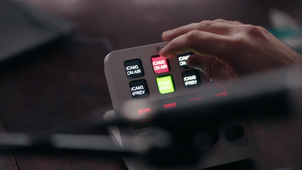 Close up of a hand adjusting controls on a video switcher on a live stream