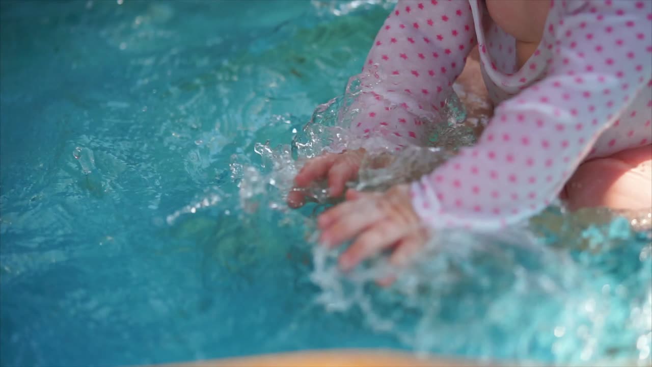 Baby splashing in a pool