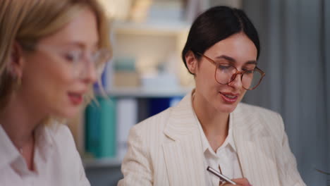 Two-Smiling-Businesswomen-Discuss-Project-Until-Evening