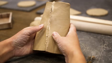 hands shaping clay vessel