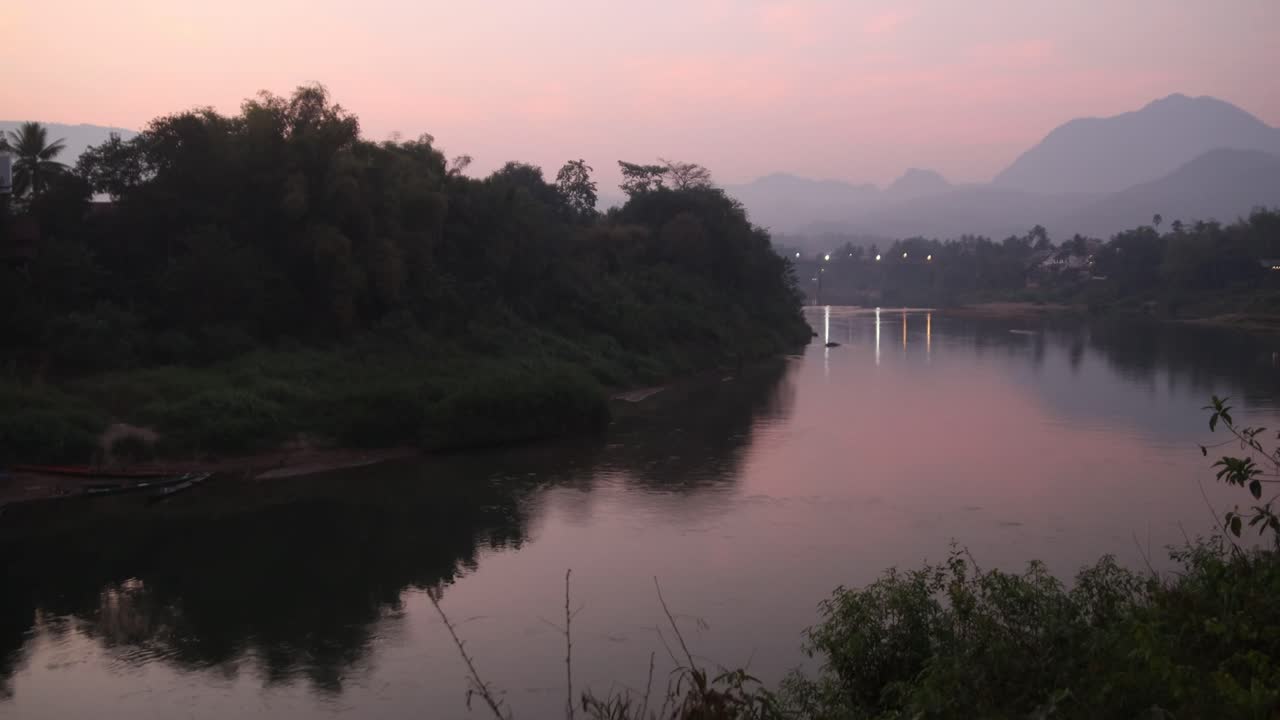 crepúsculo rosado después de la puesta del sol sobre el río en luang prabang, laos viajando por el sureste de asia