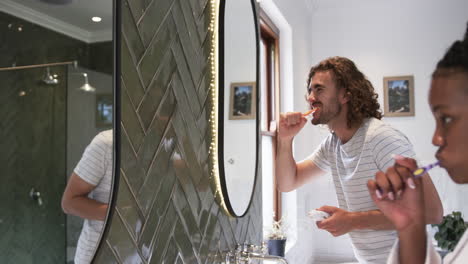 Young-Caucasian-man-brushes-his-teeth-in-a-modern-bathroom