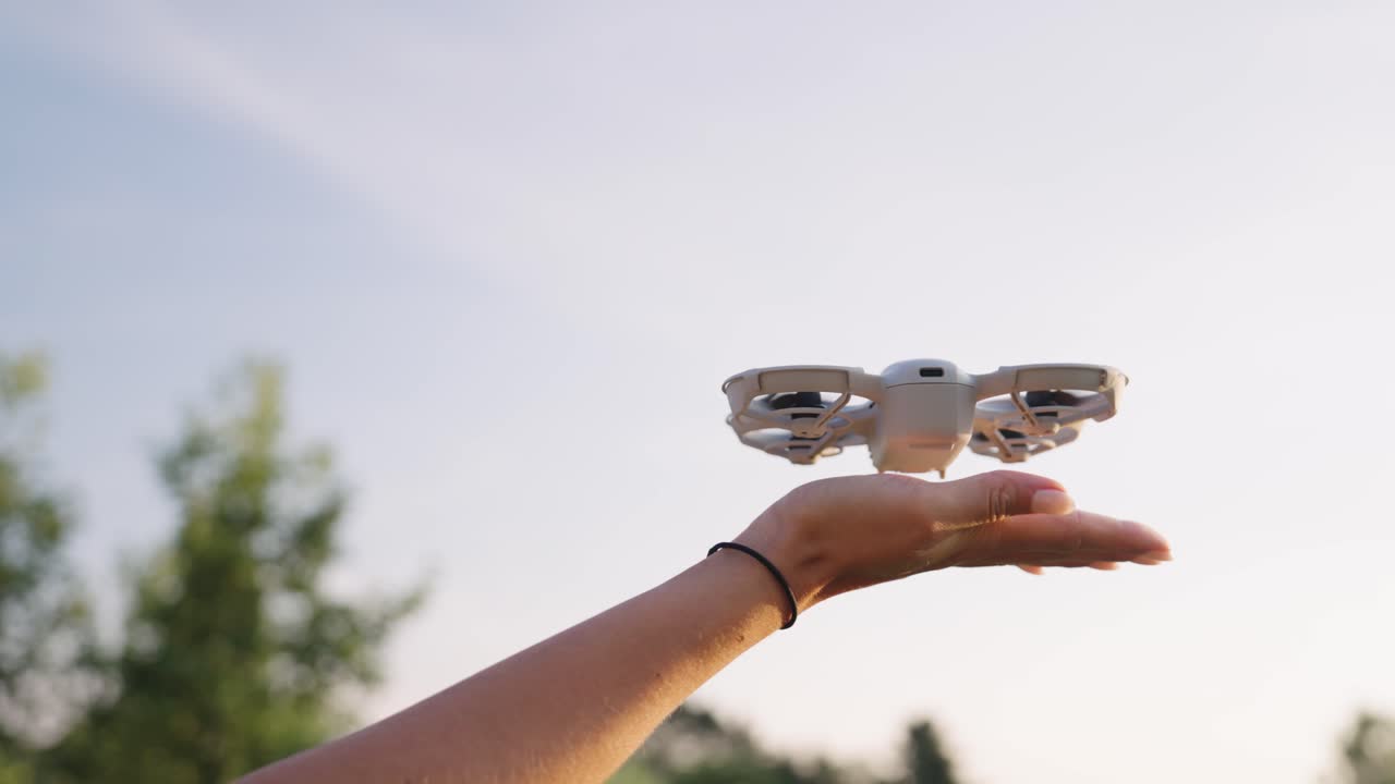 Small drone hover above extended hand, land and stop propellers, Czechia