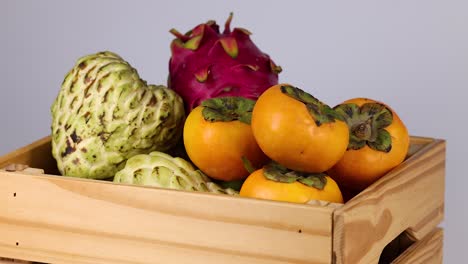 persimmons and custard apples in a crate