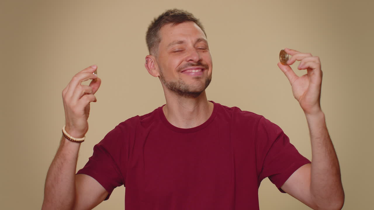 joven feliz mostrando bitcoins dorados btc, inversión en criptomonedas, minería, tecnología futura