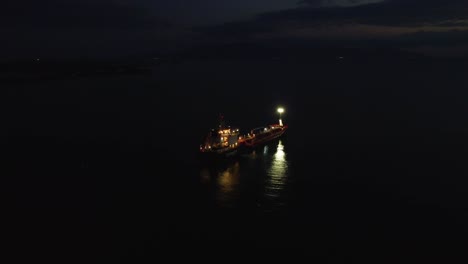 aerial pulling back over oil tanker in sea at night, industry, environment concept