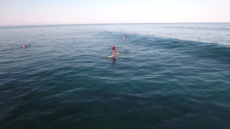 follow drone footage of stand up paddle surfer surfing the waves at cabo san lucas, mexico