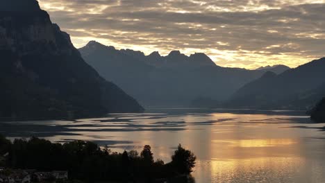 scenic view of lake walensee during sunset, with clouds beautifully reflected on the calm water