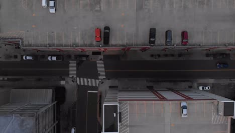 aerial footage over city flying over town and cars with people and parking garages