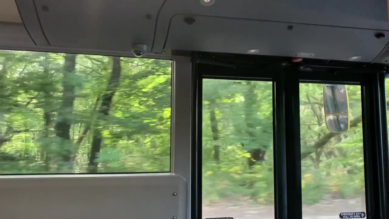 Una prospettiva in prima persona che guarda fuori dal finestrino di un autobus di Londra durante una soleggiata giornata estiva.
