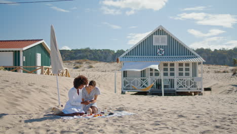 Vertikale-Aufnahme-Glücklicher-Mädchen,-Die-In-Strandhäusern-Soziale-Medien-Auf-Ihrem-Smartphone-Checken.