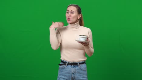 mujer joven bebiendo té y lengua ardiente. mujer delgada caucásica quemada con bebida caliente en pantalla verde. fondo chromakey