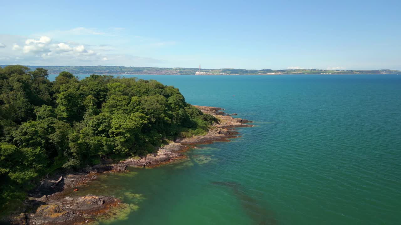 Aerial video of the forest and blue sea at Helen's Bay beach in County Down, Northern Ireland, UK. Filmed in 4K, 60FPS and with Rec709 color