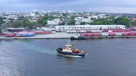 Scenic-shot-of-a-dredge-at-work,-containers-behind,-cloudy-sky-in-the-waters-of-the-ozama-river