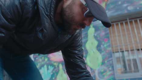 graffiti artist choosing spray paint for drawing on street wall