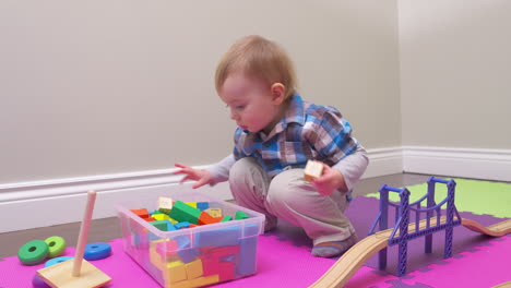 cute toddler boy exploring the toys in his playroom