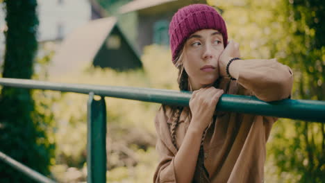 sad female tourist near railing in forest