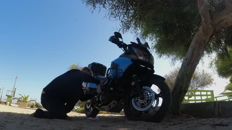 El-Motociclista-Agrega-Aceite-De-Motor-A-La-Motocicleta-A-La-Sombra-De-Un-árbol-Afuera