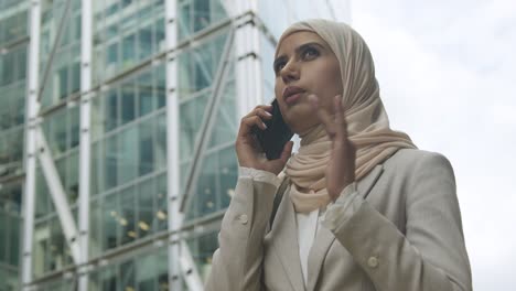 Muslim-Businesswoman-On-Mobile-Phone-Standing-Outside-Office-In-City-5