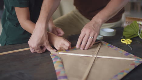 father and daughter making a kite together