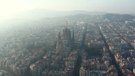 Forwards-fly-above-Eixample-district.-Aerial-view-of-famous-unfinished-basilica-Sagrada-Familia.-Barcelona,-Spain