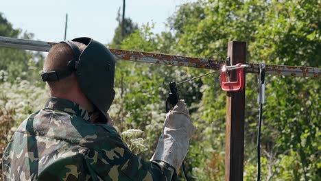 soldaduras de hombre de cámara lenta y verificaciones parte de la valla fijada con abrazadera