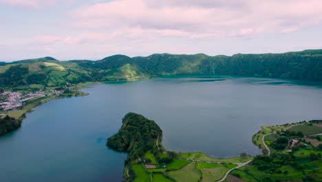 Ariel-shot-of-São-Miguel-Island,-drone-flying-above-the-lake-and-green-mountains