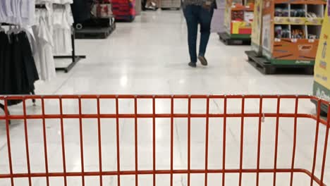 a shopping cart being steered around a supermarket