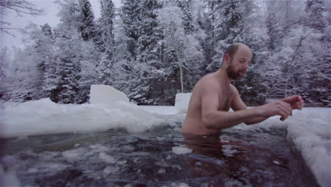 un bañista de hielo se sumerge repetidamente bajo el agua helada para su rutina