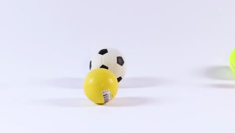 various colorful balls bounce energetically against a plain white backdrop, showcasing dynamic motion and playful interaction.